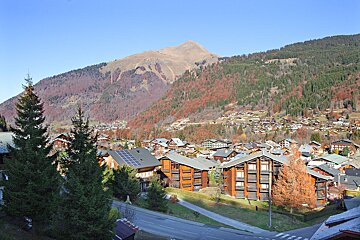 A small town in the mountains with a mountain in the background