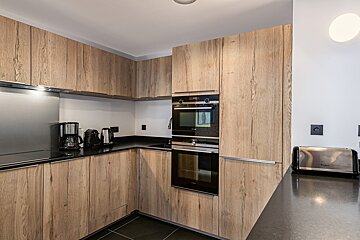 A kitchen with wooden cabinets and stainless steel appliances