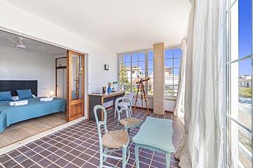 A bedroom with two beds and a desk with a telescope on it