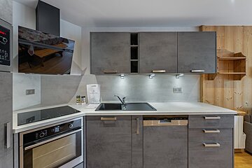 A kitchen with a clock on the wall that says 10:08