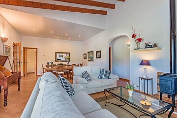 A living room with a white couch and a glass coffee table