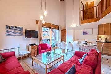 A living room with a red couch and white chairs