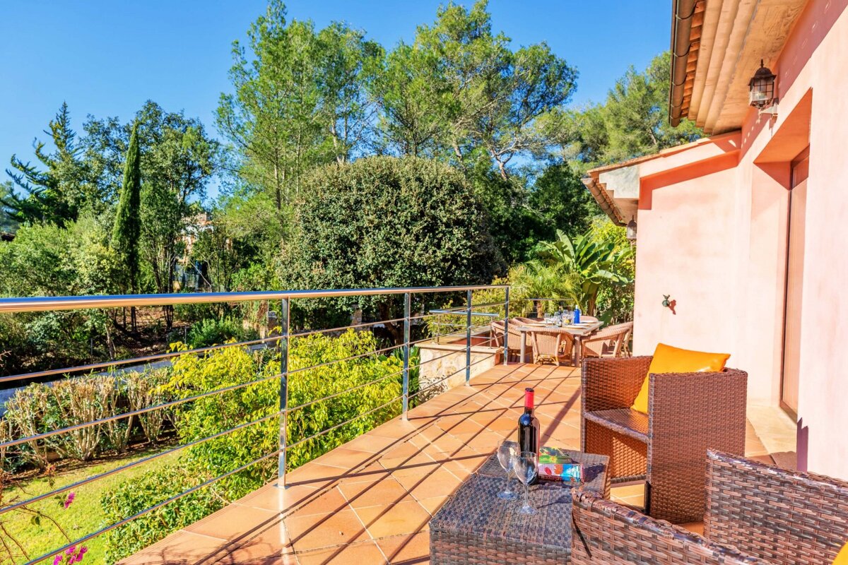 A bottle of wine sits on a table on a balcony