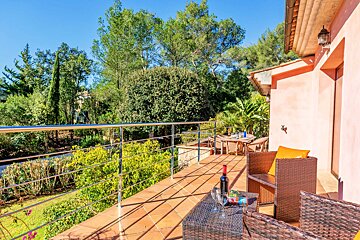 A bottle of wine sits on a table on a balcony