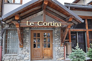 A building with a sign that says le cortina on it