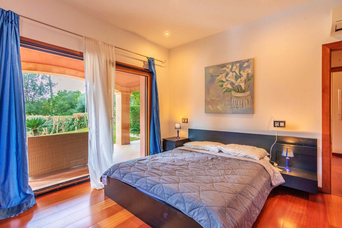 A bedroom with a bed and a painting on the wall