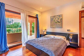 A bedroom with a bed and a painting on the wall