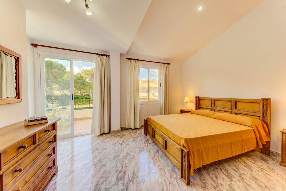 A bedroom with a large bed and a dresser