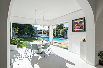 A room with a table and chairs and a painting on the wall