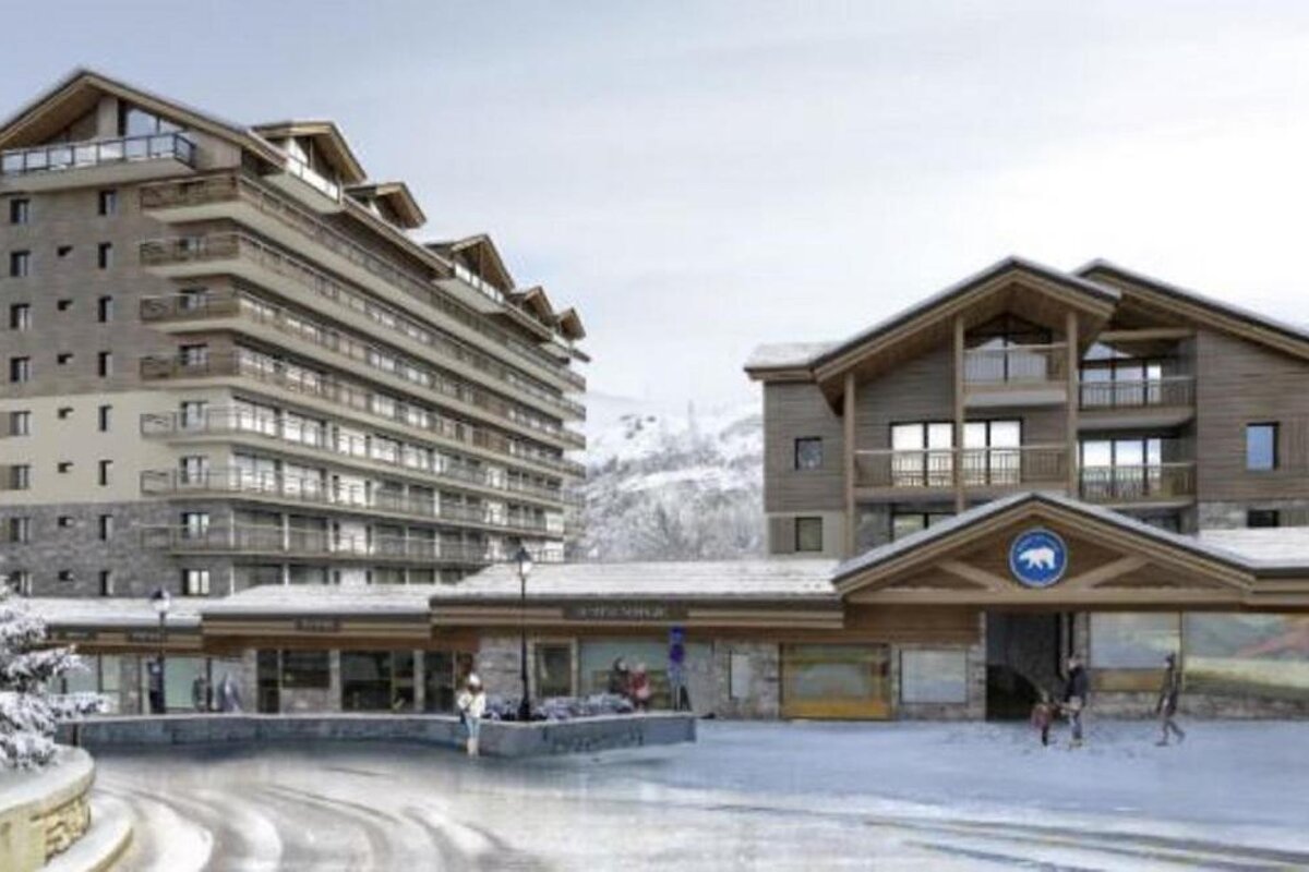 A large wooden house with a balcony overlooking a snowy mountain