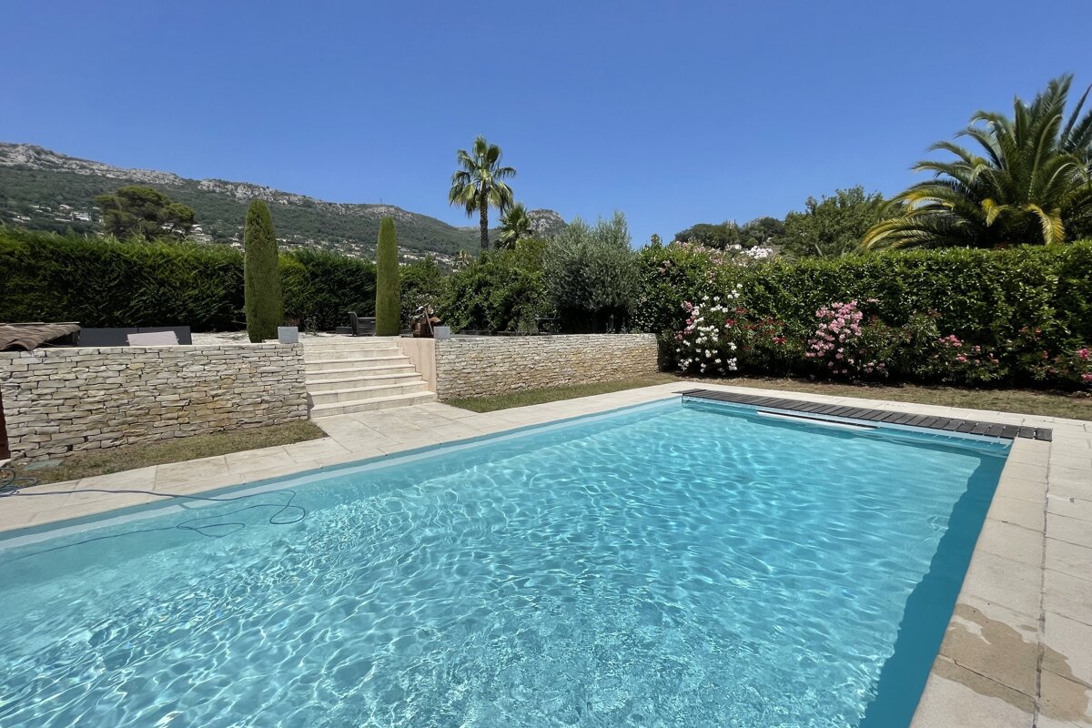 A large swimming pool with a stone wall surrounding it