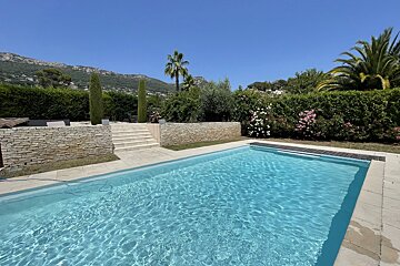 A large swimming pool with a stone wall surrounding it