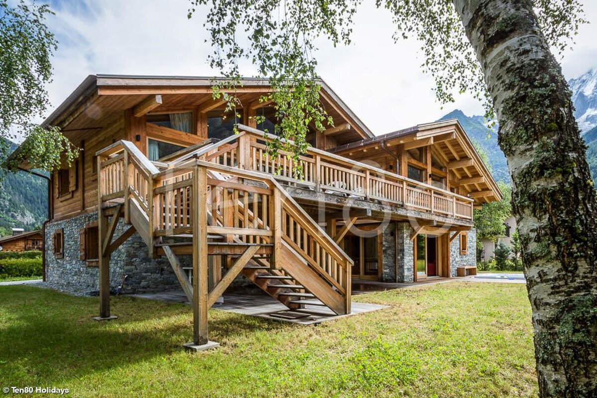 A large wooden house with stairs leading up to it