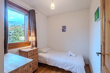 A bedroom with a bed dresser and a lamp