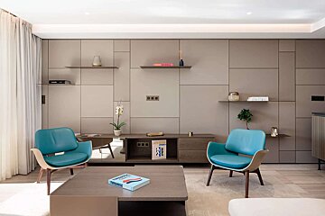 A living room with two blue chairs and a coffee table