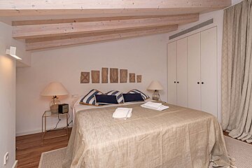 A bedroom with a bed and two lamps