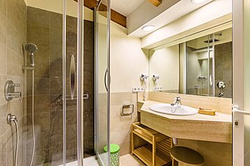 A bathroom with a sink and a walk in shower
