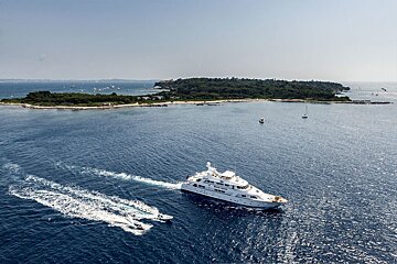 A large white yacht is in the middle of a large body of water