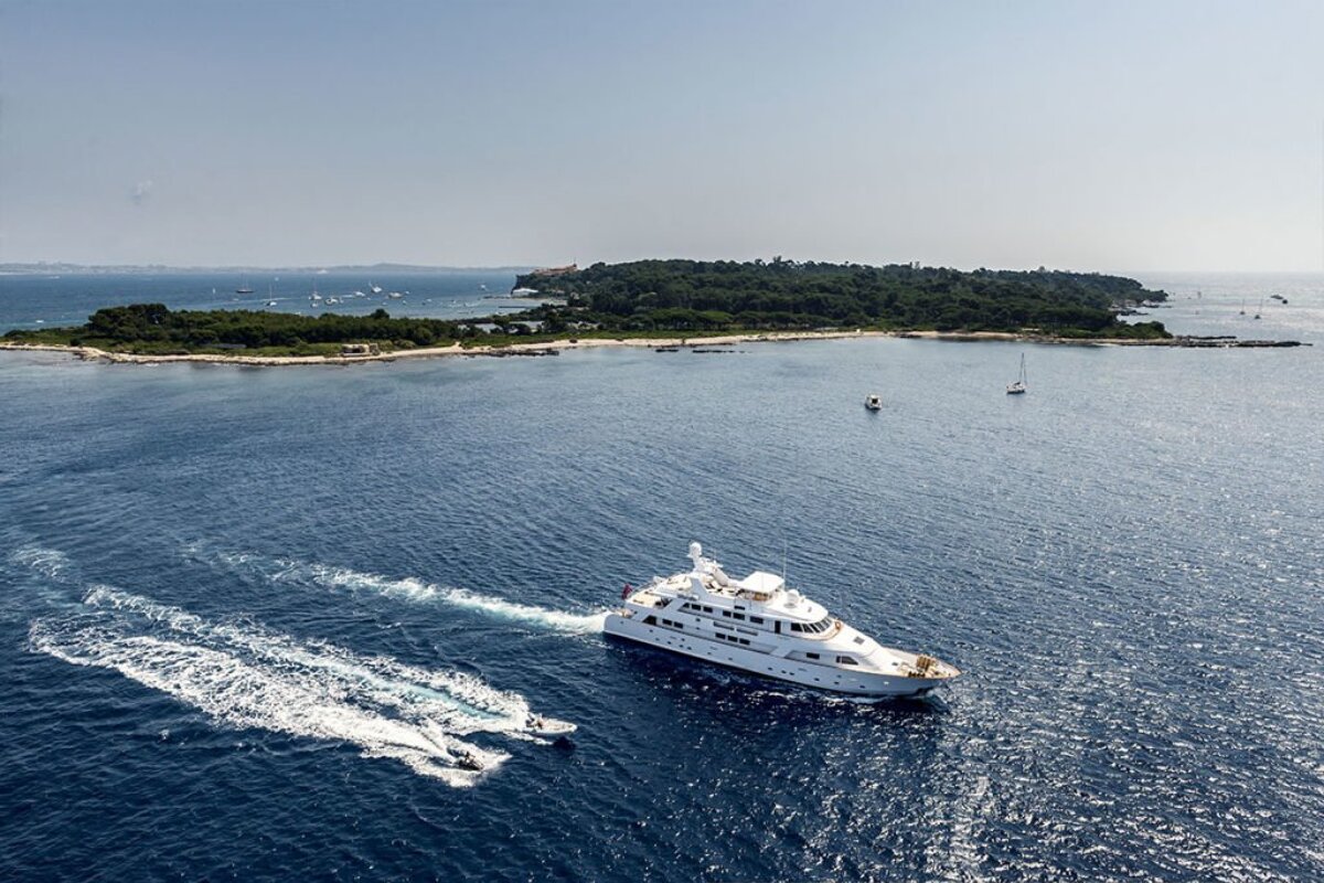 A large white yacht is in the middle of a large body of water