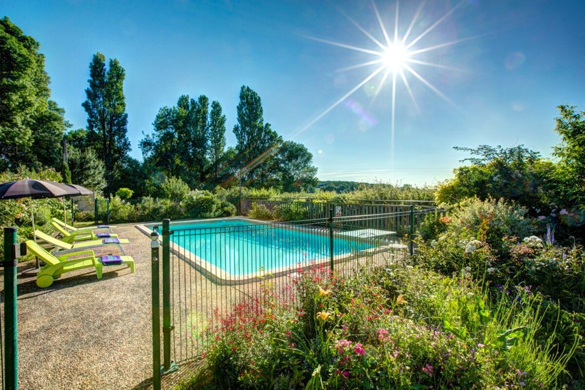 The sun is shining brightly over a swimming pool