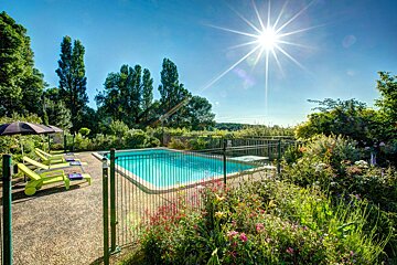 The sun is shining brightly over a swimming pool