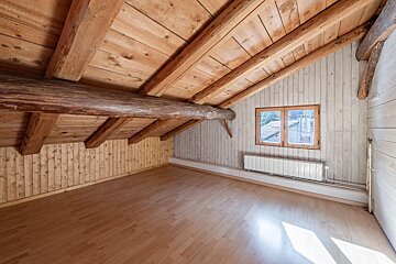 An empty room with a wooden ceiling and a window