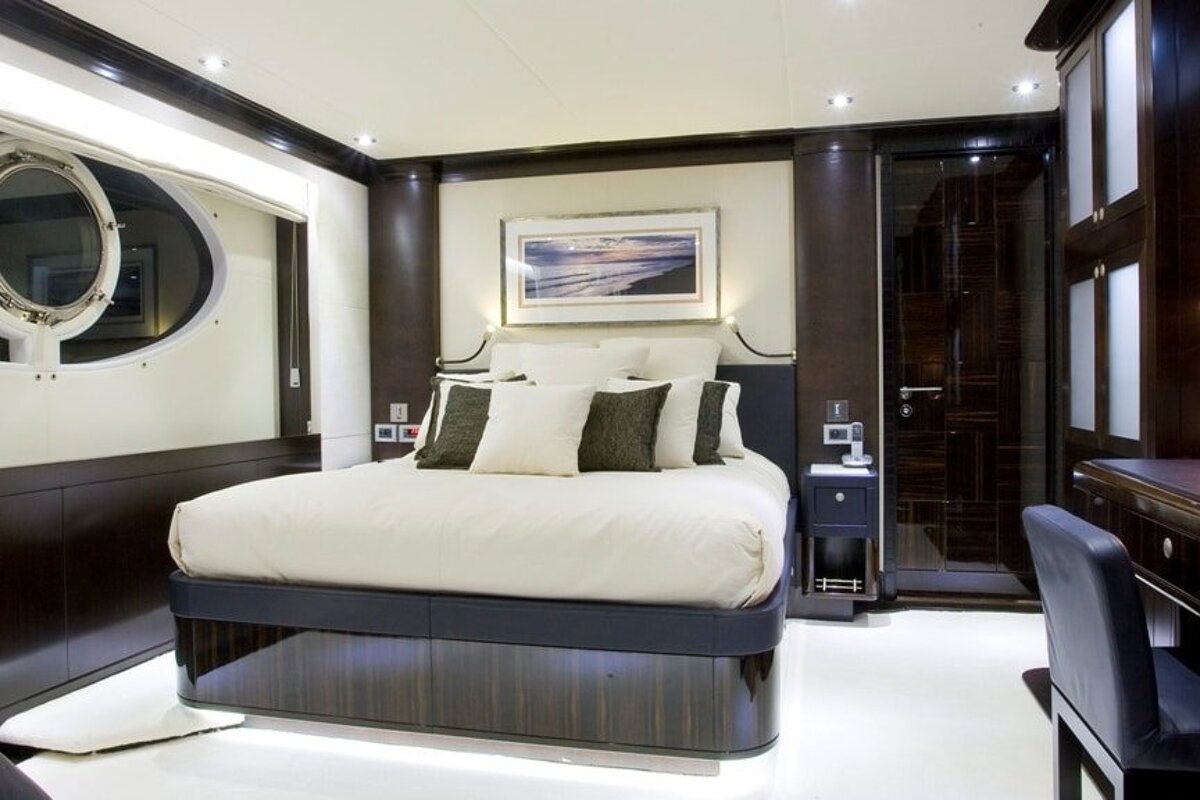 A bedroom with a large bed and a picture on the wall