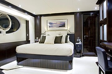 A bedroom with a large bed and a picture on the wall