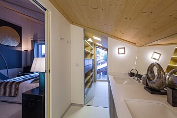 A bathroom with a sliding glass door leading to a bedroom