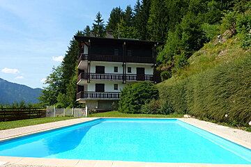 A large house with a swimming pool in front of it