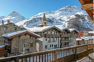 A view of a snowy mountain town from a balcony