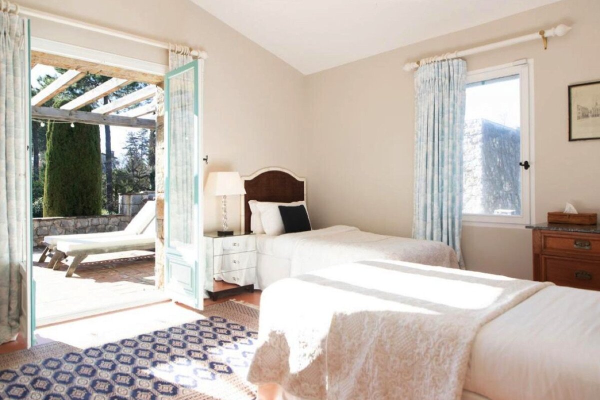 A bedroom with two beds and a blue rug