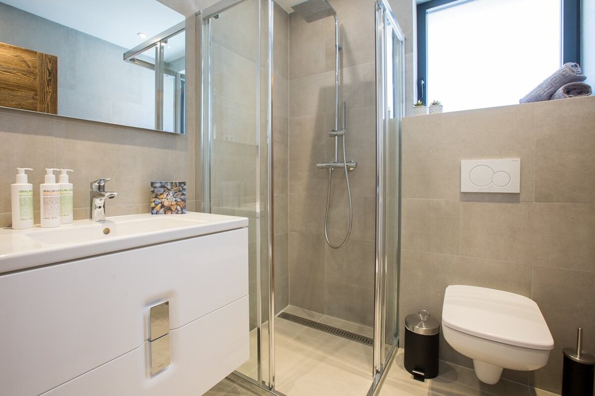 A bathroom with a toilet a sink and a shower