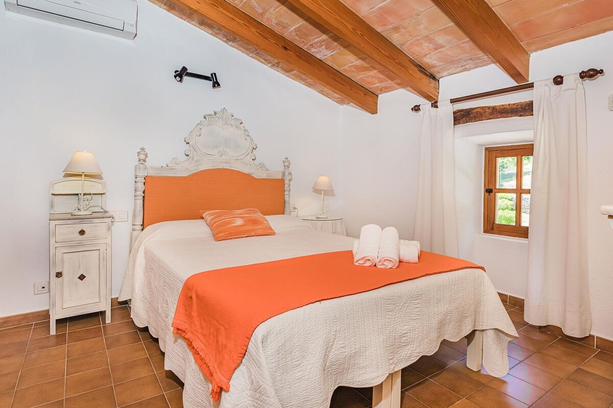 A bedroom with a large bed and a window