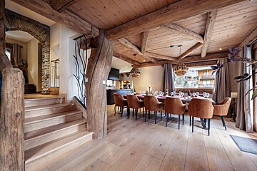 A dining room with a table and chairs and stairs