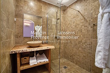 A bathroom with a sink and a walk in shower made in provence by janssens immobilier