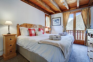 A bedroom with a bed and a picture on the wall