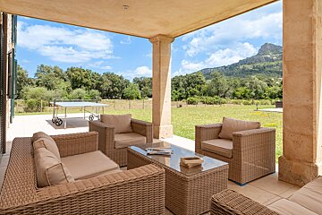 A patio with wicker furniture and a ping pong table
