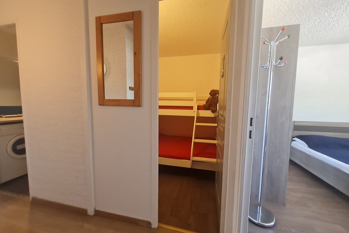 A bedroom with bunk beds and a mirror on the wall