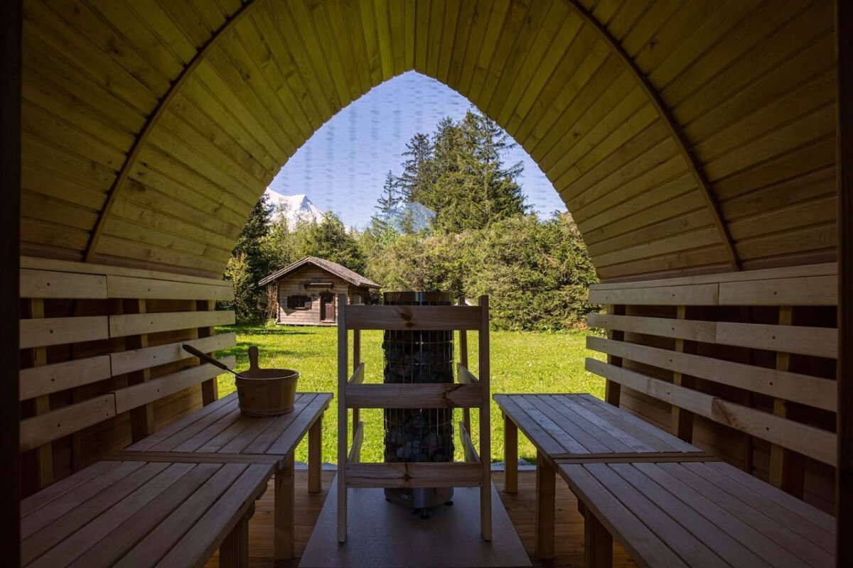 A wooden sauna with a view of a cabin in the woods