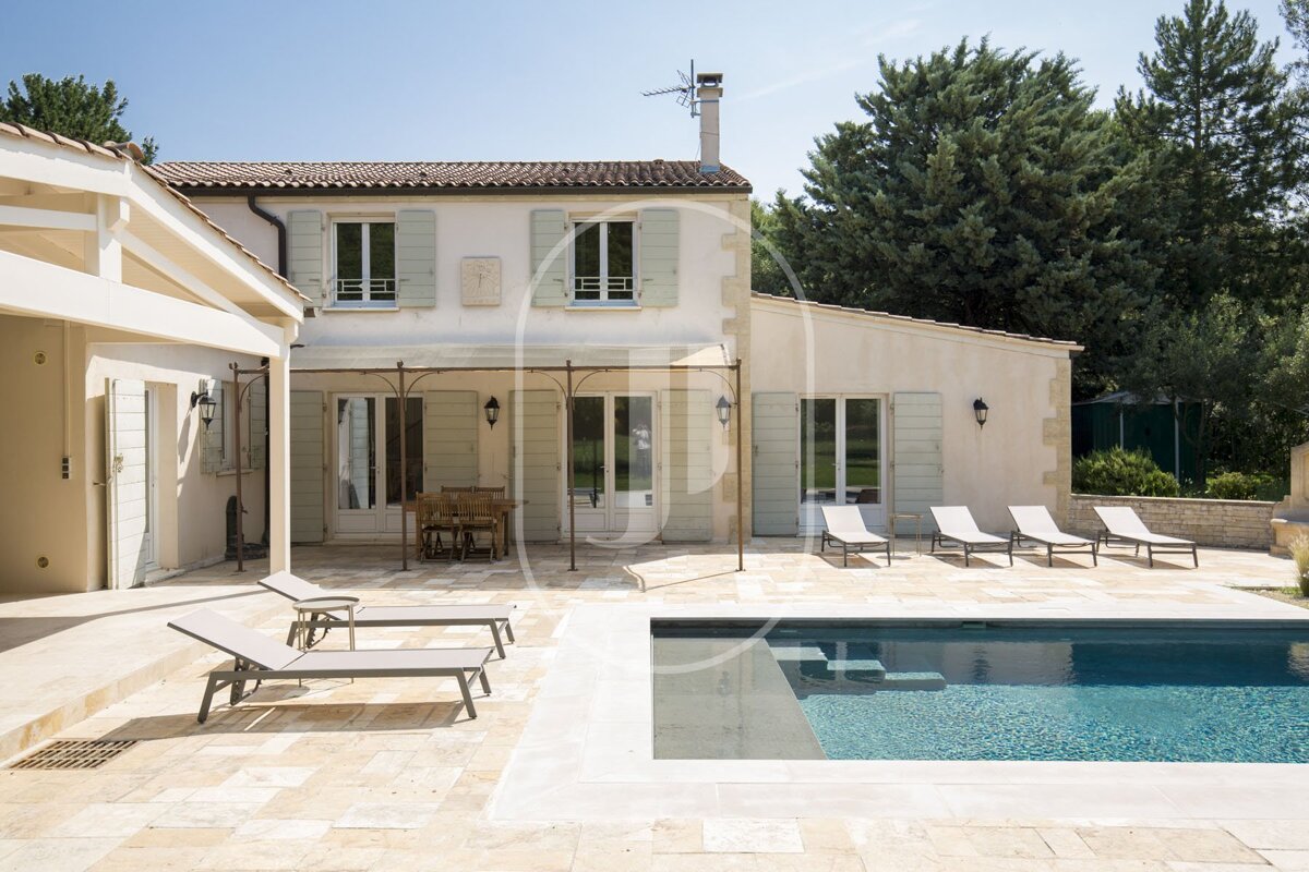 A house with a large swimming pool in front of it