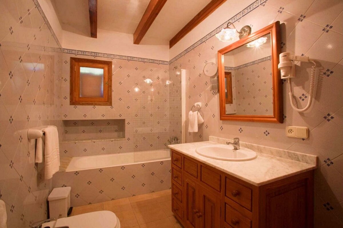A bathroom with a sink a toilet and a mirror