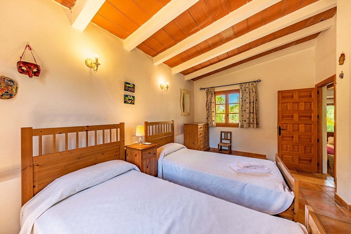 A bedroom with two twin beds and a dresser
