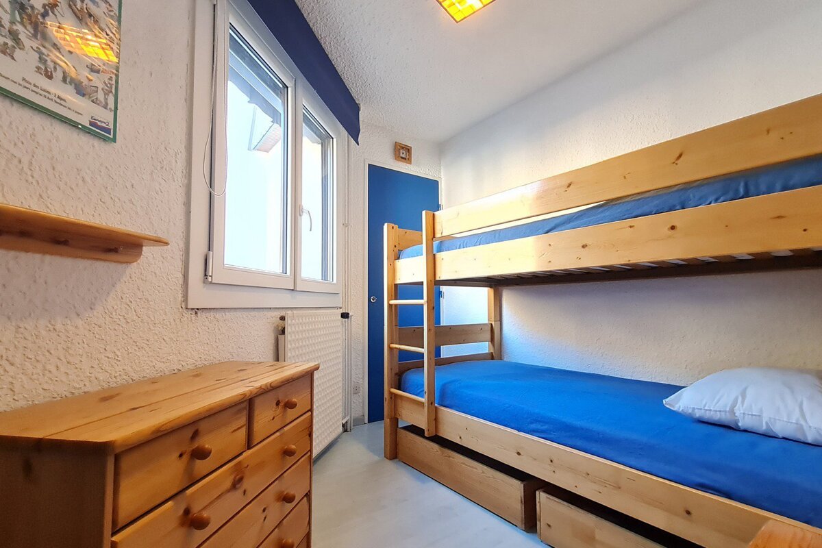 A bedroom with a bunk bed and a dresser