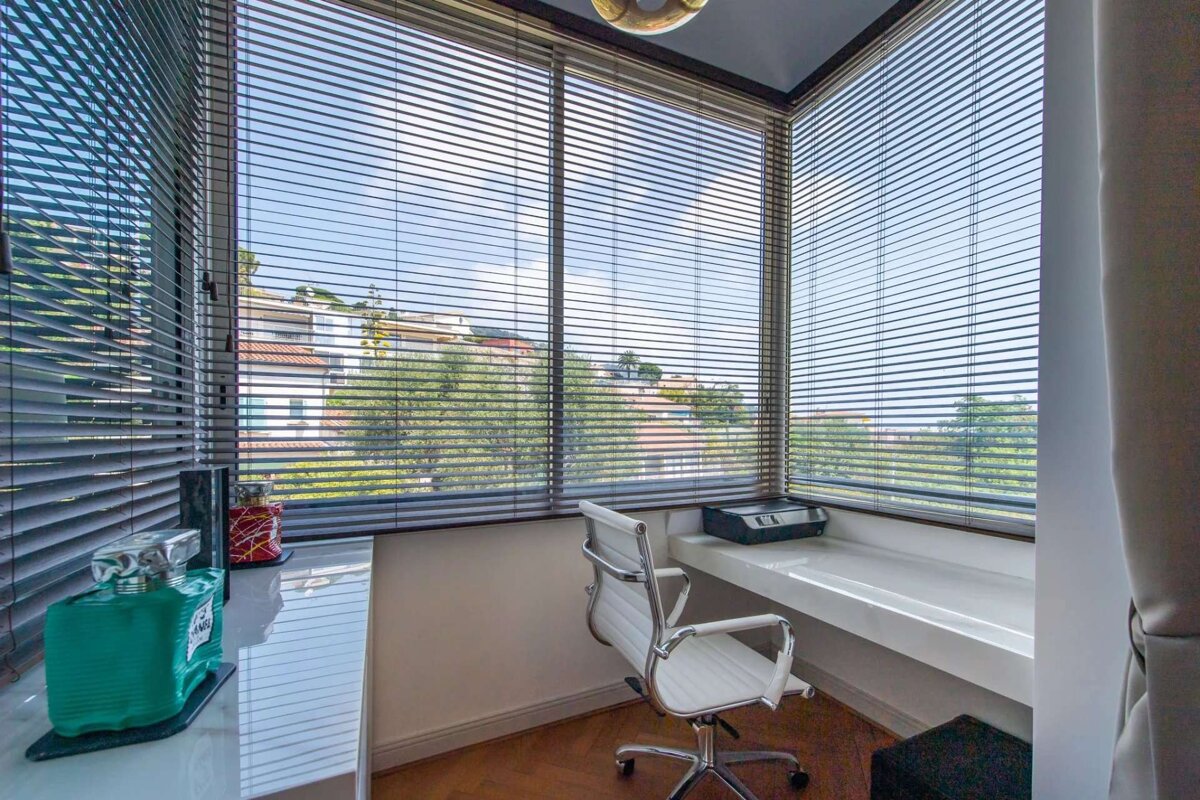 A white office chair sits in front of a window with blinds