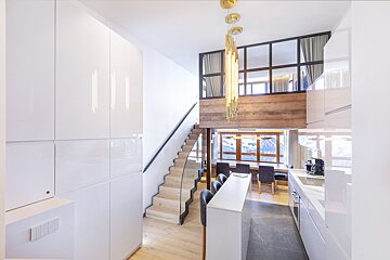 A kitchen with a staircase leading up to the second floor