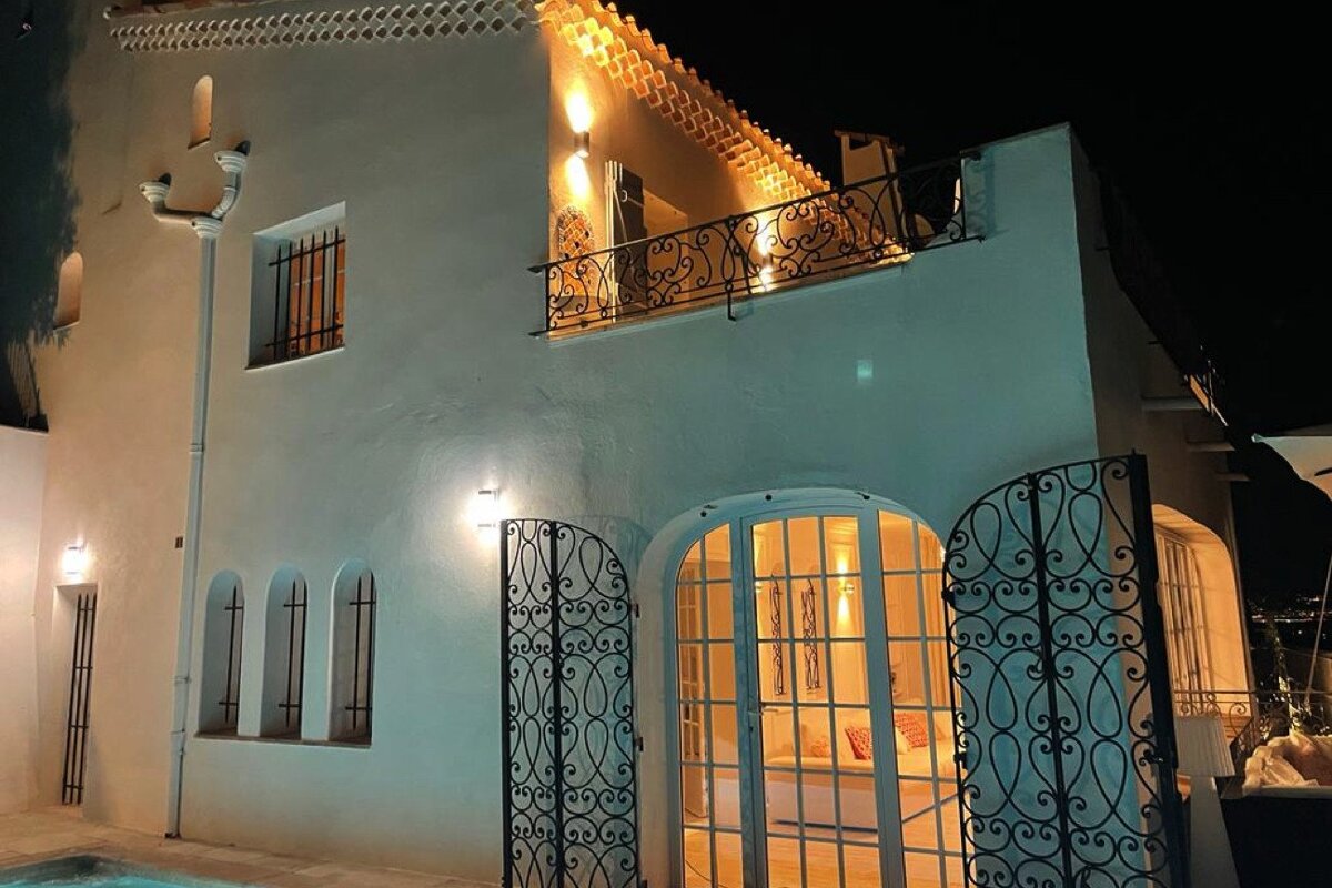 A white building with a balcony and a wrought iron gate