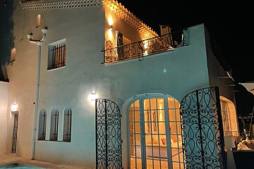 A white building with a balcony and a wrought iron gate