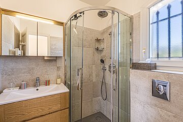 A bathroom with a shower stall and a sink