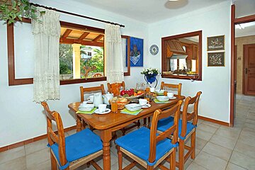 A dining room with a table and chairs and a window